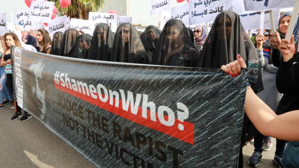 Activists hold banners against sexual assaults during the 16th edition of the Beirut Marathon on November 11, 2018. 
ANWAR AMRO / AFP