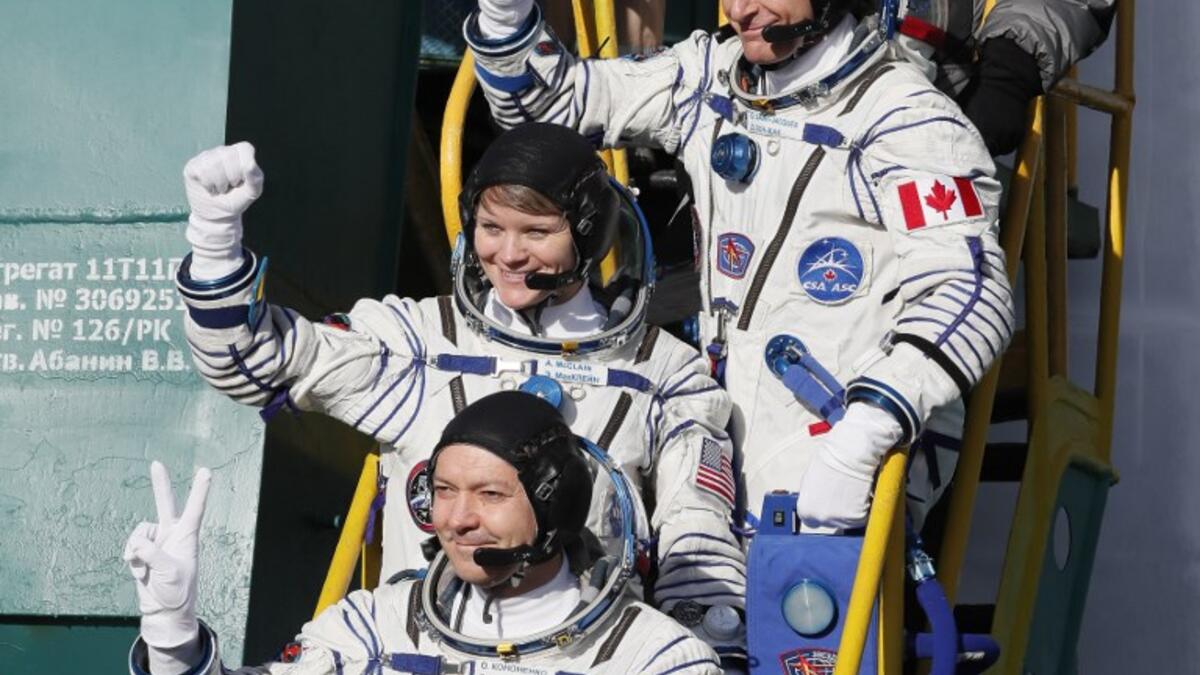 Top-bottom: Members of the International Space Station (ISS) expedition 58/59, gesture as they board the Soyuz MS-11 spacecraft shortly before the launch at the Russian-leased Baikonur cosmodrome in Kazakhstan on December 3, 2018. 
Shamil ZHUMATOV / POOL / AFP