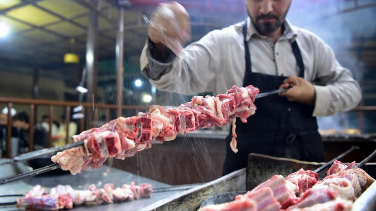 Pakistani cook prepares meat to be grilled at the Charsi (Hashish) Tikka restaurant in Namak Mandi in Peshawar.
ABDUL MAJEED / AFP