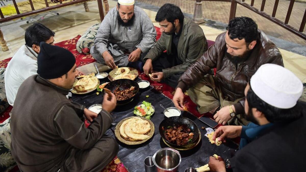 Pakistani customers eat grilled meat at the Charsi (Hashish) Tikka restaurant in Namak Mandi in Peshawar.
ABDUL MAJEED / AFP