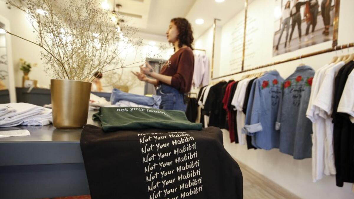 Palestinian fashion designer Yasmeen Mjalli speaks while standing in her clothing shop where her label collection "BabyFist" carrying anti-sexual harassment slogans is showcased, in Ramallah in the occupied West Bank 
ABBAS MOMANI / AFP