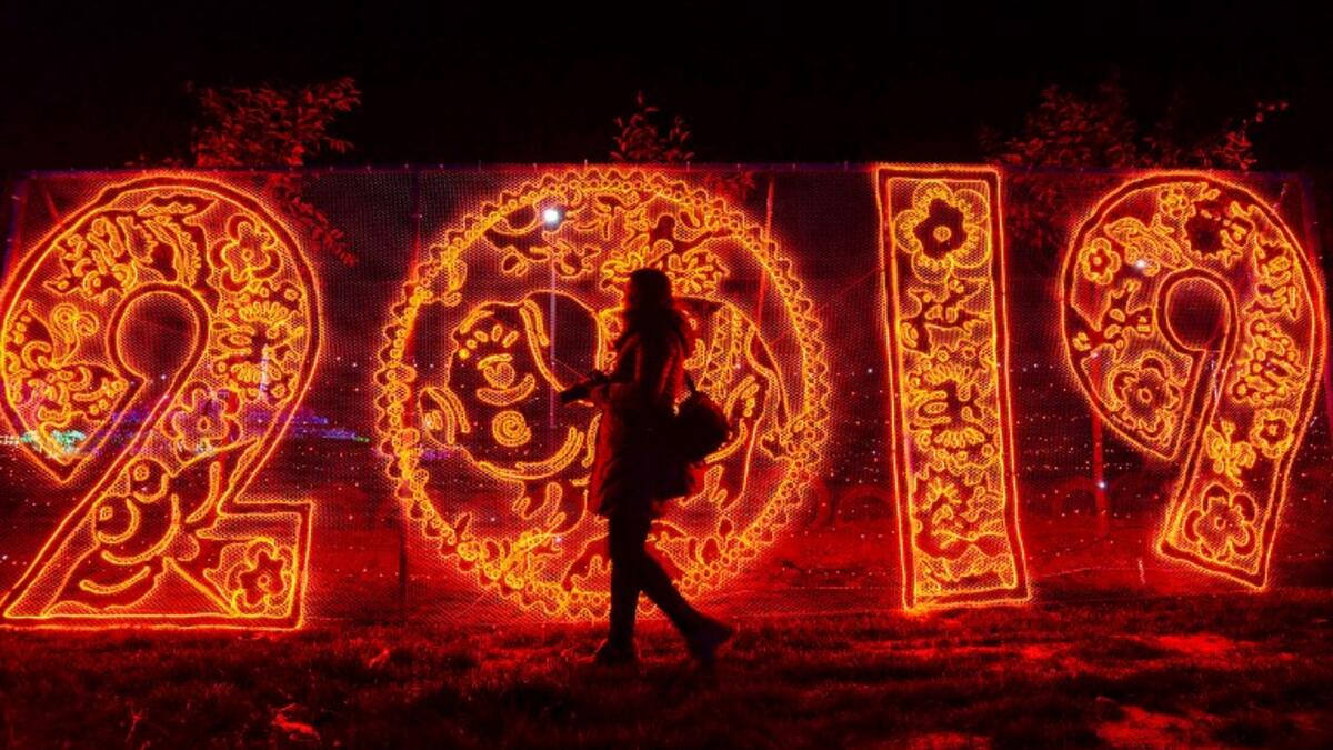 This photo taken on December 20, 2018 shows a woman walking past illuminated decorations at a lighting display in Handan in China's northern Hebei province. 
STR / AFP