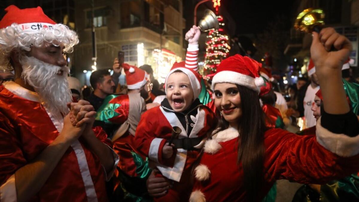 Syrian people dressed as Santa Claus walk in the capital Damascus' central neighbourhood of Qassaa to celebrate Christmas early on December 22, 2018. 
LOUAI BESHARA / AFP