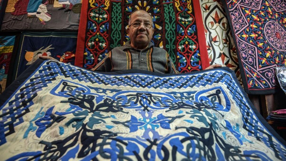 An Egyptian craftsman showcases a tapestry in his shop in Khayamiya Street, or the Street of Tent-makers, in the old city of the Egyptian capital Cairo. Mohamed el-Shahed / AFP