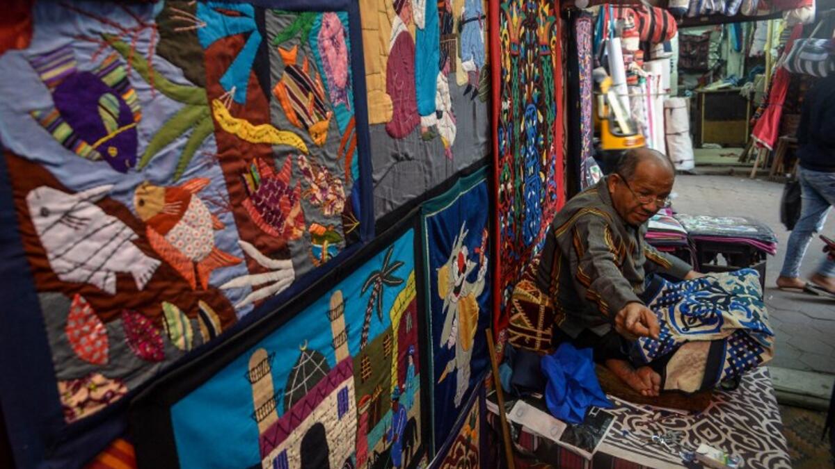 An Egyptian craftsman gestures as he sits while working on a tapestry in his shop in Khayamiya Street, or the Street of Tent-makers, in the old city of the Egyptian capital Cairo
Mohamed el-Shahed / AFP