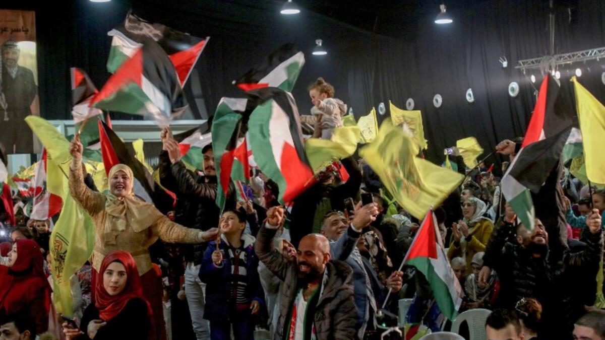 People wave flags of Palestine and Fatah as they attend a mass wedding ceremony 
Mahmoud ZAYYAT / AFP