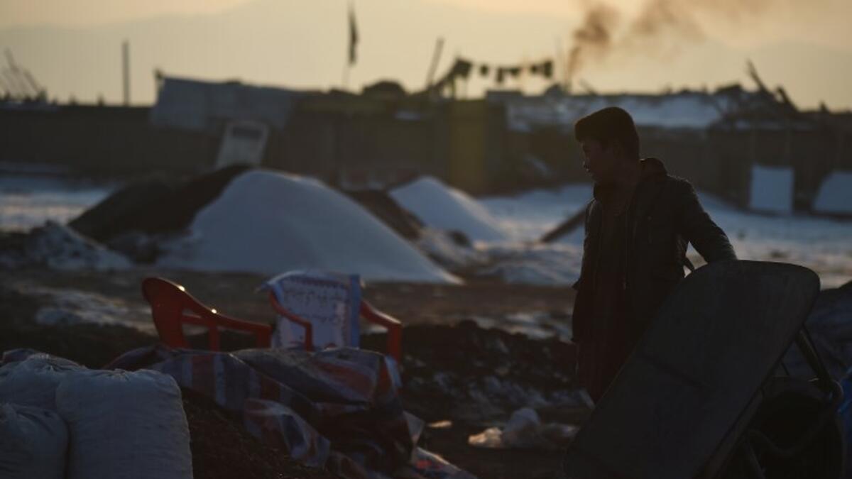 In this picture, an Afghan day labourer stands next to a wheelbarrow at a coal yard amid heavy smog conditions in the outskirts of Kabul. 
WAKIL KOHSAR / AFP