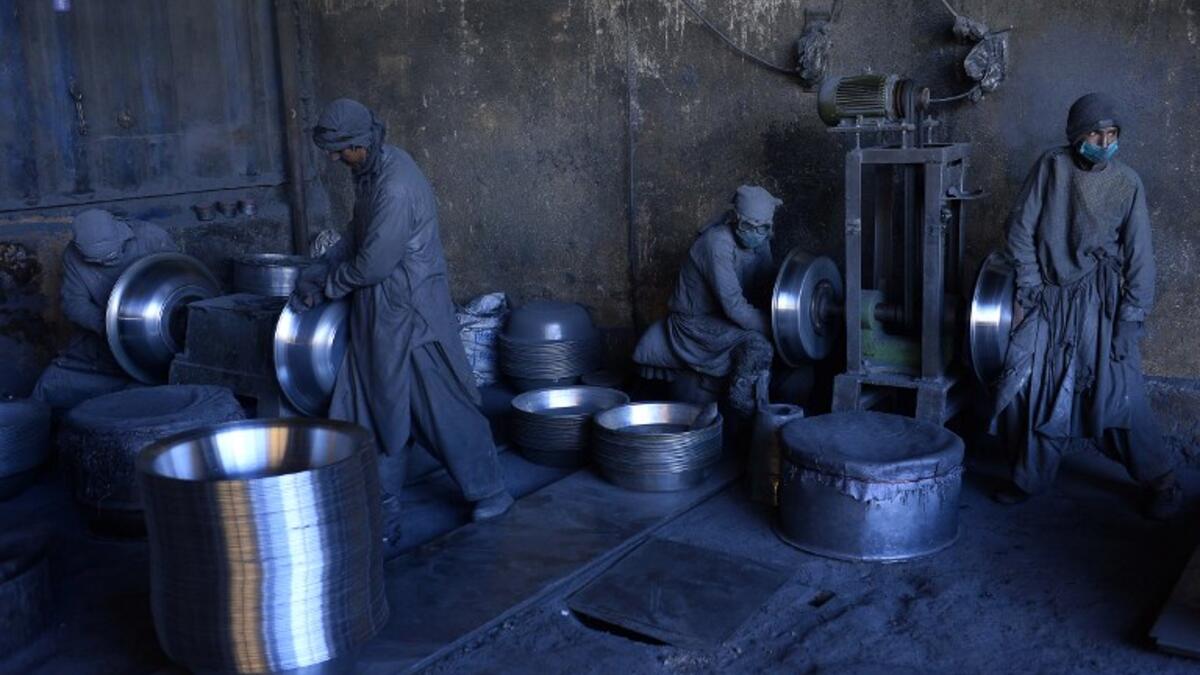 In this photo  Afghan labourers polish metal pots at an aluminum factory in Herat. 
HOSHANG HASHIMI / AFP
