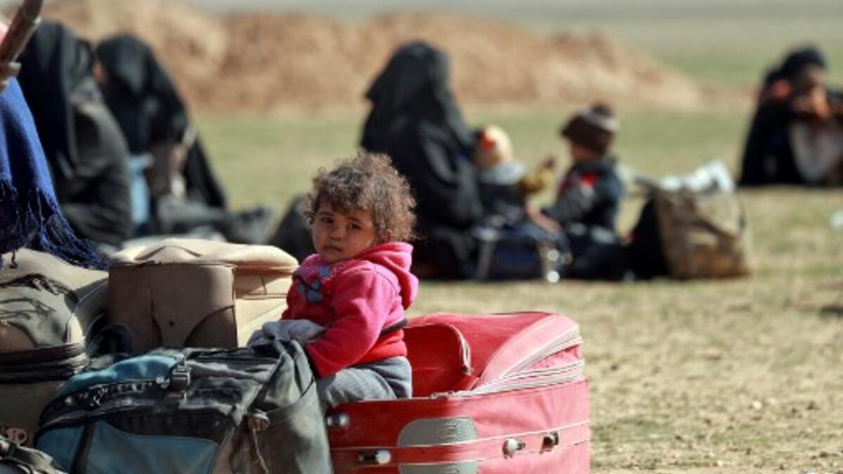 People who fled battles between Syrian Democratic Forces (SDF) and ISIS fighters in the Syrian village of Baghouz, arrive after crossing a desert in the back of a truck to a region controlled by the SFD in the countryside of the Deir Ezzor province. Delil SOULEIMAN / AFP