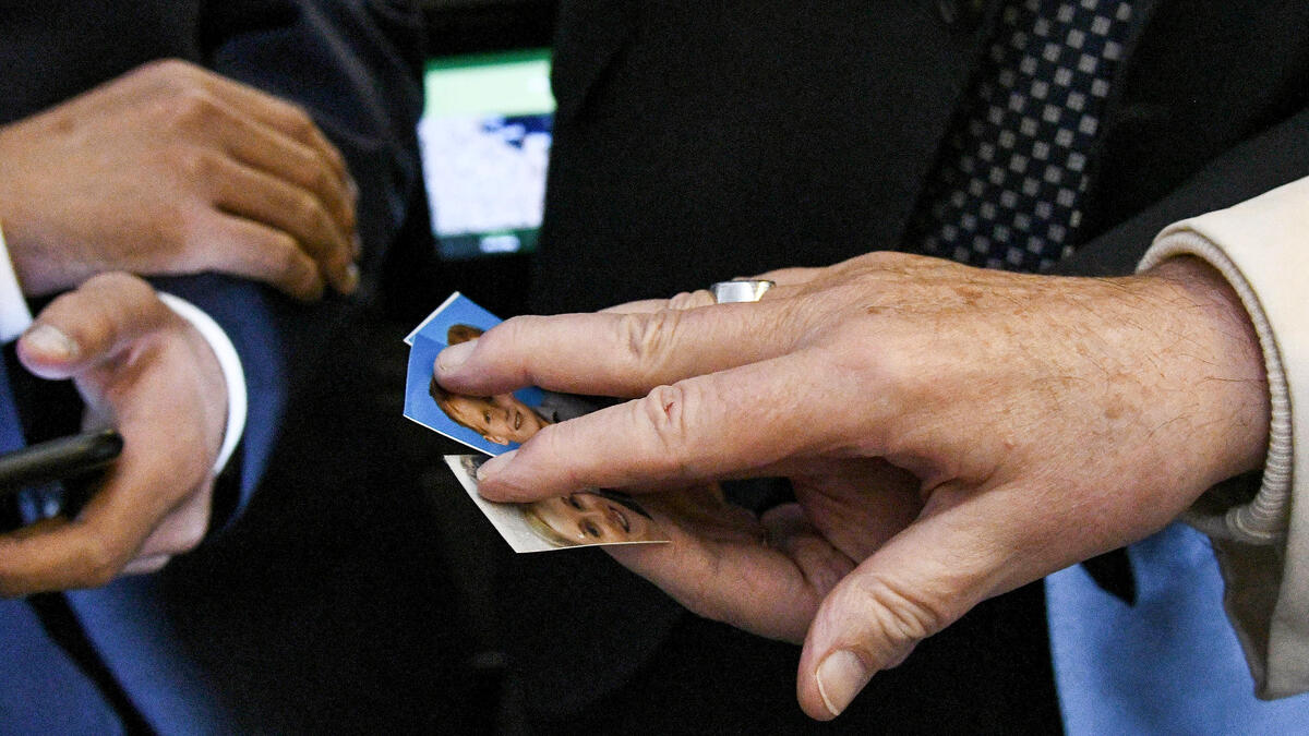 Pope Francis blesses photographs of children as he welcomes journalists aboard his plane after take-off on his way to Abu Dhabi, on February 3, 2019. 
Vincenzo PINTO / AFP