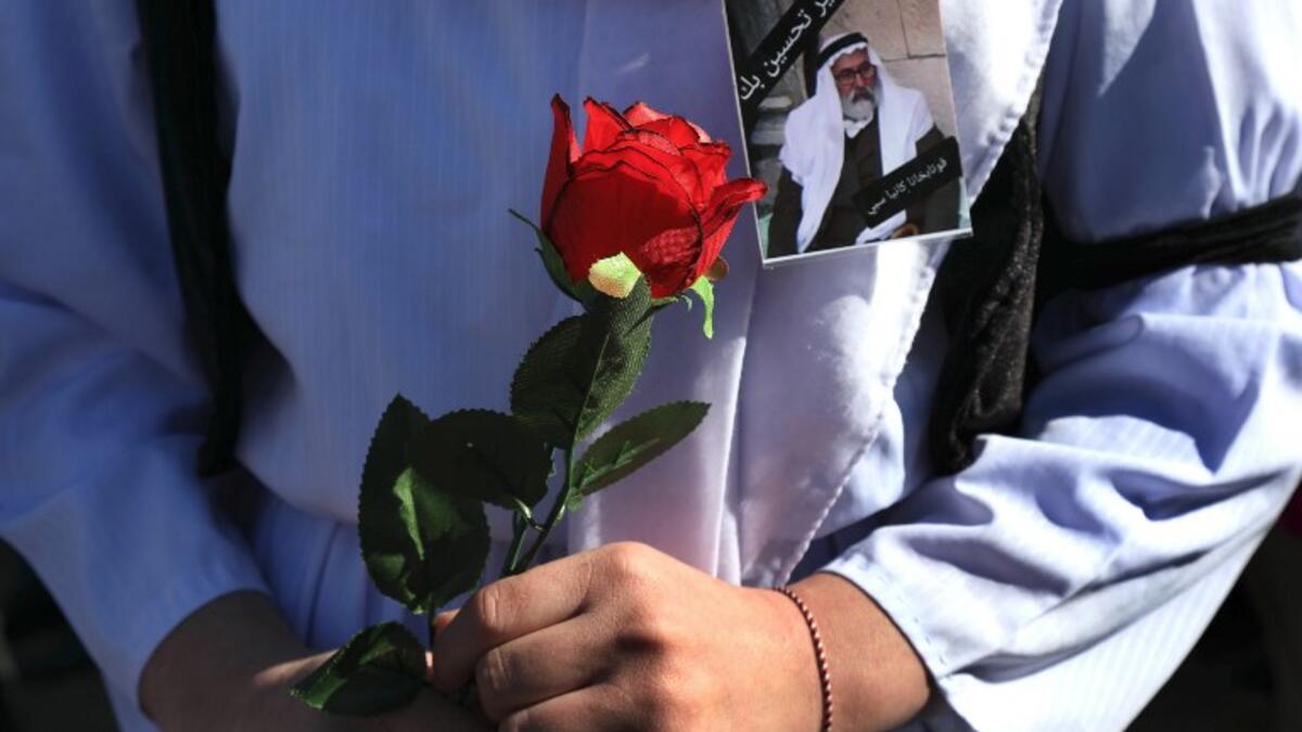An Iraqi Yazidi carries a rose during the funeral of the Mir Takhsin-Beg (Tahseen Said Ali), the hereditary leader of the Yazidi community in the world, in the town of Sheikhan, 50km northeast of Mosul. 
SAFIN HAMED / AFP