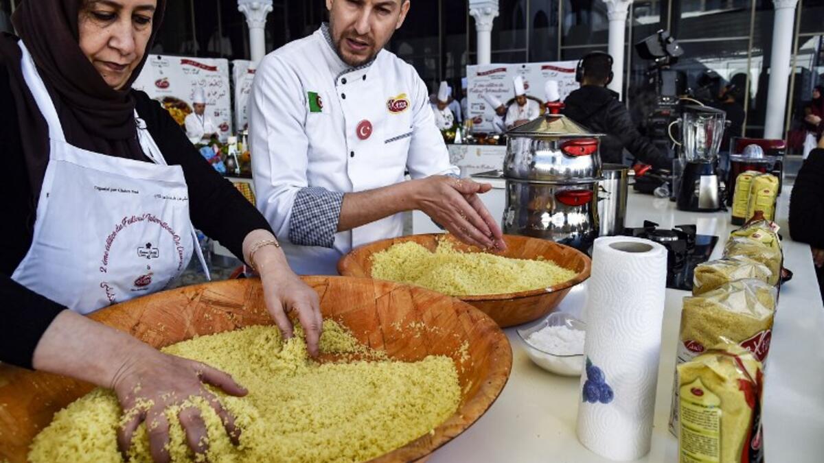 An Algerian chef directs a woman as they prepare couscous during the 2nd edition of the International Couscous Festival at the Moufdi Zakaria Palace of Culture in Algeria
RYAD KRAMDI / AFP