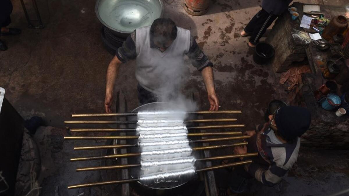 Pakistani workers dye fabric threads at a factory in Lahore 
ARIF ALI / AFP