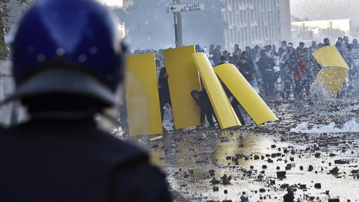 Algerian protesters use makeshift barriers during clashes with security forces amidst protests against ailing President Abdelaziz Bouteflika's bid for a fifth term in power in the capital 
RYAD KRAMDI / AFP