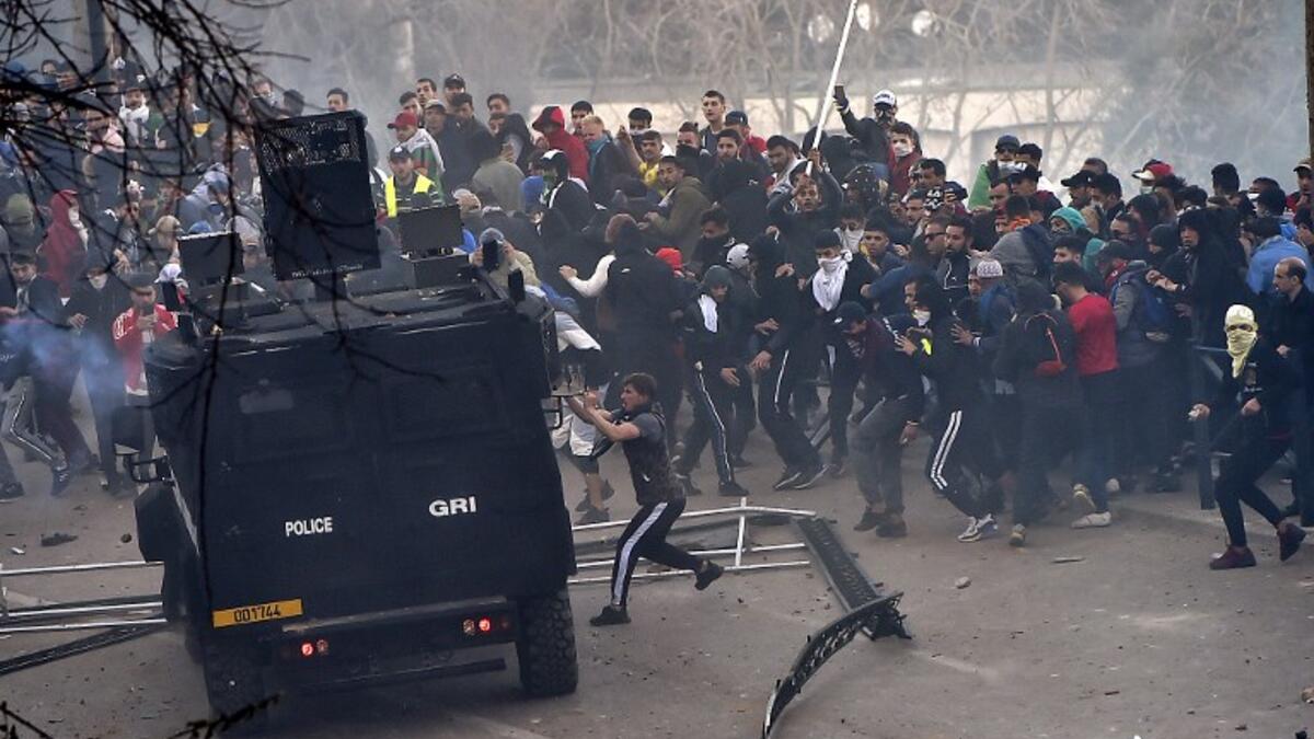 Algerian protesters attempt to overturn a riot police vehicle during clashes in the capital 
RYAD KRAMDI / AFP
