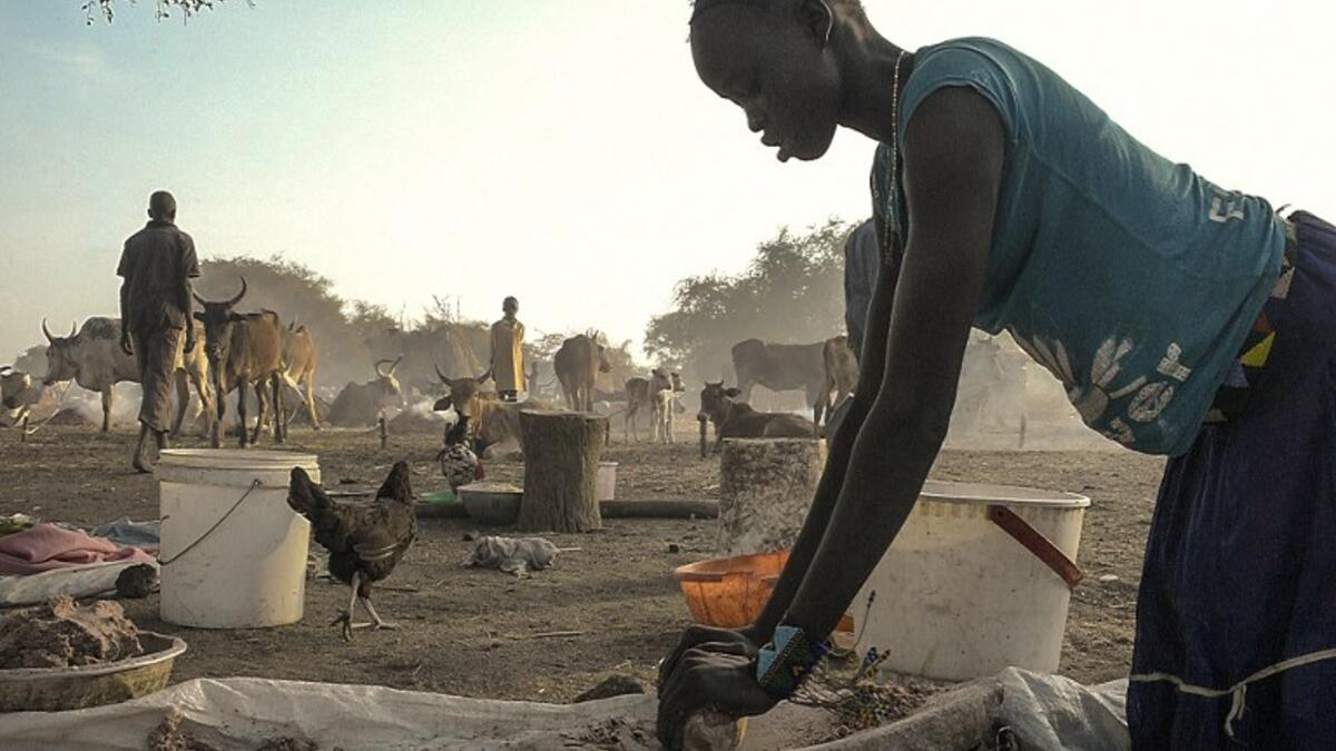 A woman grinds traditional millet, ahead of cattle vaccinations administered by the International Committee of the Red Cross (ICRC) with the help of local community workers, at Kirgui village in Udier, South Sudan 
SIMON MAINA / AFP