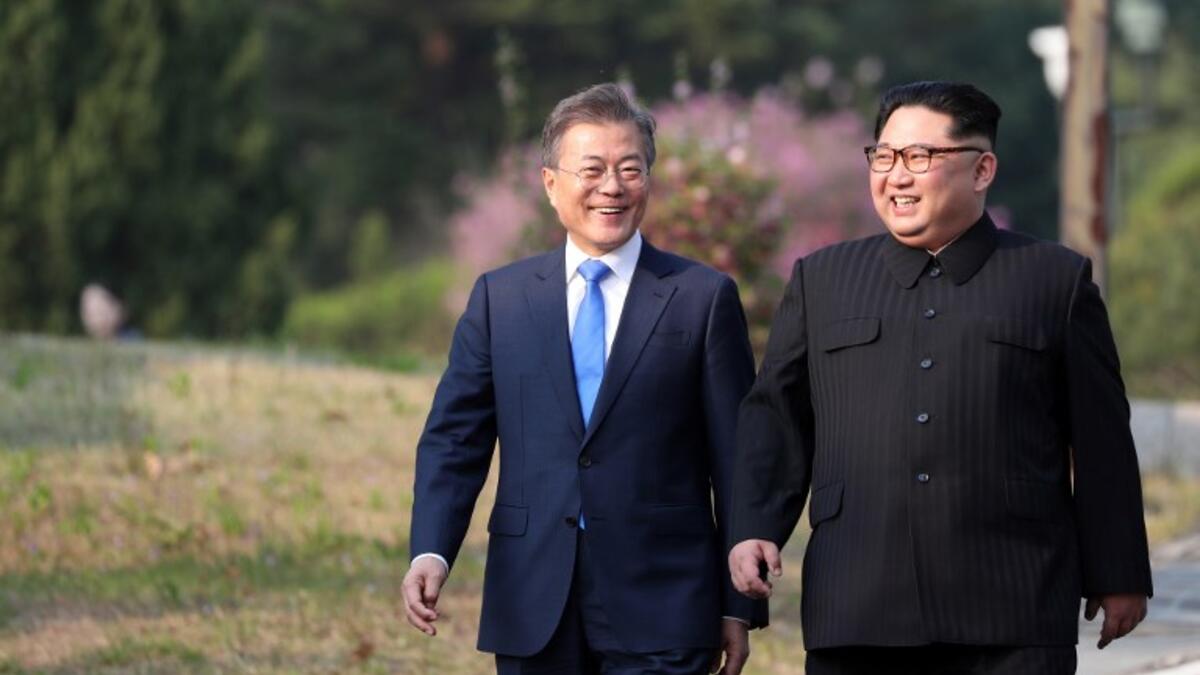 North Korea's leader Kim Jong Un (R) and South Korea's President Moon Jae-in (L) walk together after a tree-planting ceremony. Korea Summit Press Pool / AFP