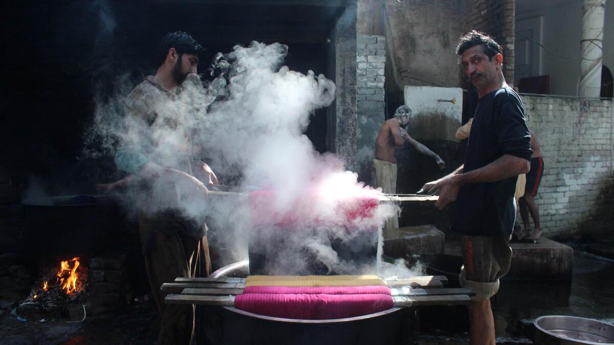 Pakistani workers dye fabric threads at a factory in Lahore (Twitter)