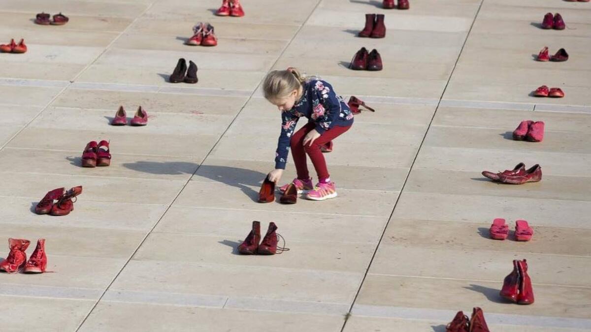 Israelis walk past an installation of red shoes during a rally against domestic violence in the Israeli coastal city of Tel Aviv on December 4, 2018 (Twitter)