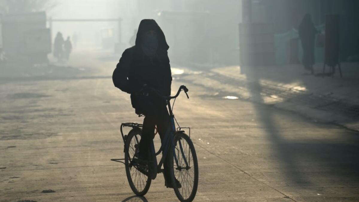In this photograph, an Afghan resident rides a bicycle with his face covered amid heavy smog conditions in Afghanistan's capital Kabul. 
WAKIL KOHSAR / AFP
