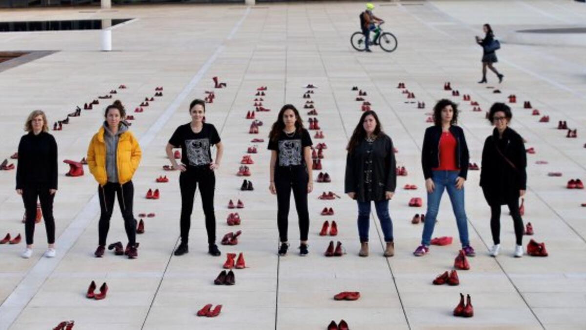 Israelis walk past an installation of red shoes during a rally against domestic violence in the Israeli coastal city of Tel Aviv on December 4, 2018 (Twitter)