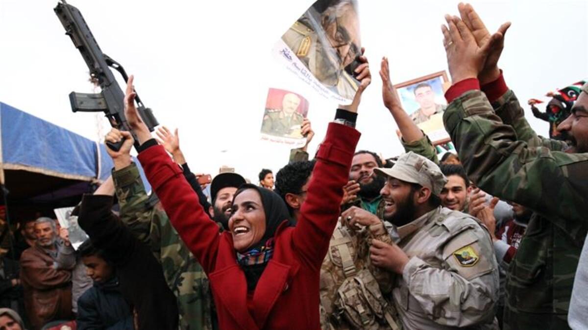 The Military Strongman:

After another brief spell in the US, Haftar returned to Libya and announced that the General National Congress, the country’s elected authority, had been dissolved. Those who opposed him described this as a coup attempt, however he denied the allegation.

(Photo: A woman waves a picture of Haftar. AFP)