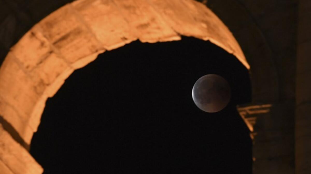 This picture shows the full moon during a 'blood moon' eclipse behind the ancient Colosseum on July 28, 2018 in Rome. (AFP/Tiziana FABI)