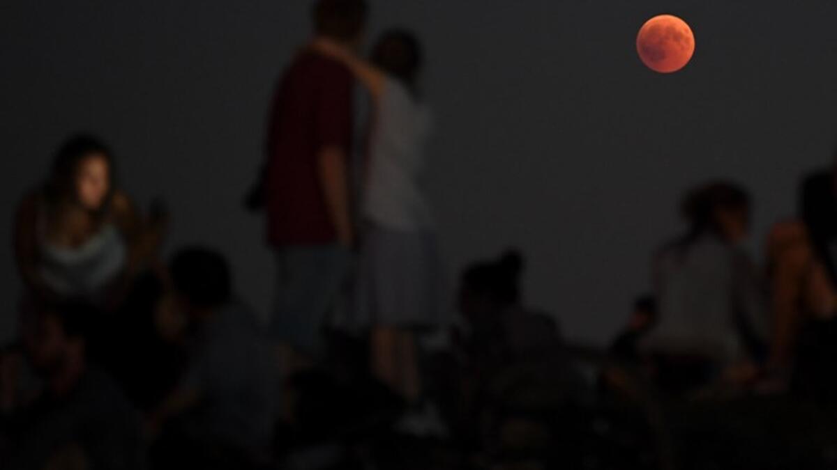 People watch the total lunar eclipse in the Olympic park in Munich, southern Germany, on July 27, 2018. (AFP, CHRISTOF STACHE)