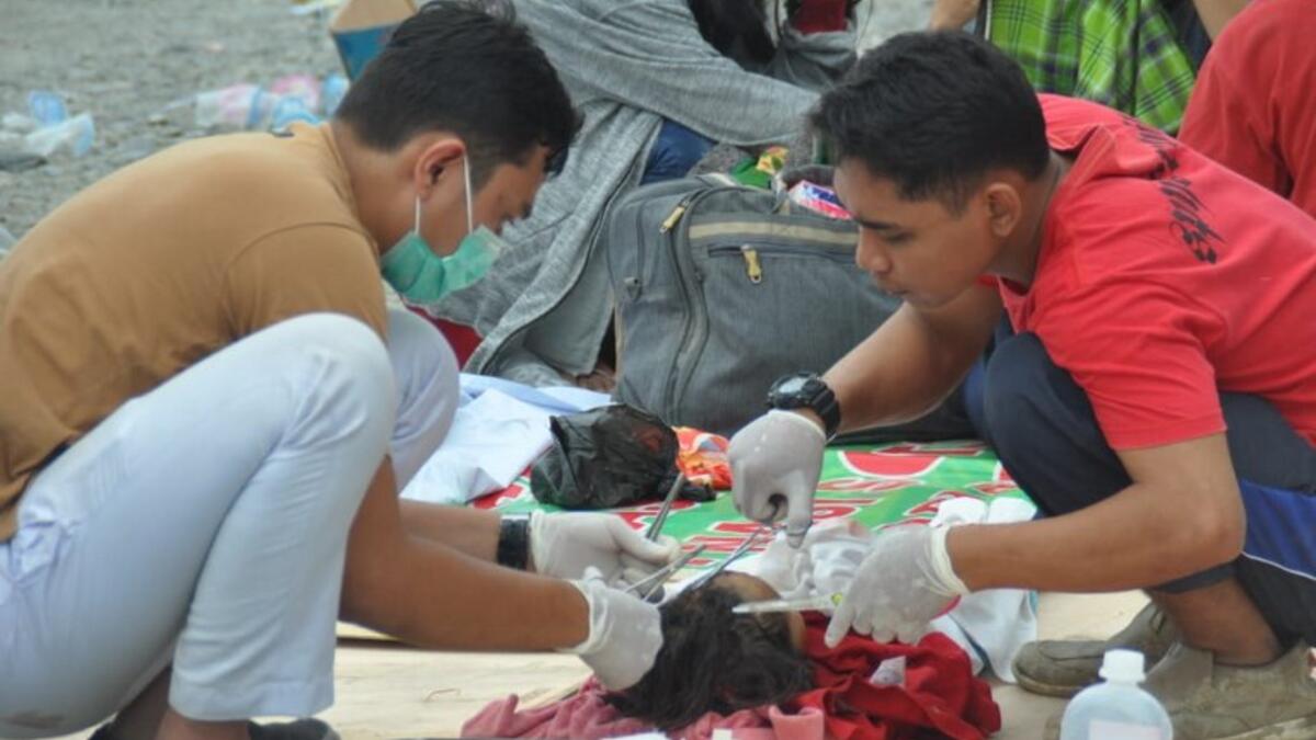 Medical team members help patients outside a hospital after an earthquake and a tsunami hit Palu, on Sulawesi island on September 29, 2018. (MUHAMMAD RIFKI / AFP)