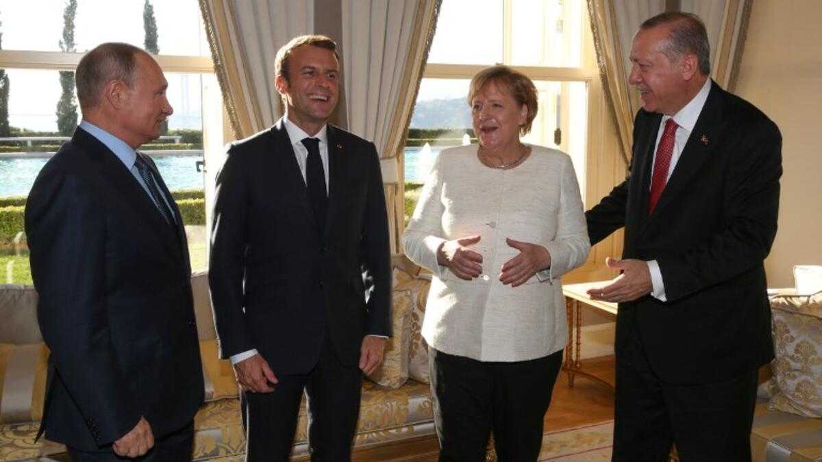 (From L) Russian President Vladimir Putin, French President Emmanuel Macron, German Chancellor Angela Merkel and Turkish President Recep Tayyip Erdogan share a laugh during the "Four-day Istanbul summit on Syria", at Vahdettin Mansion in Istanbul, on October 27, 2018. (Murat KULA / POOL / AFP)