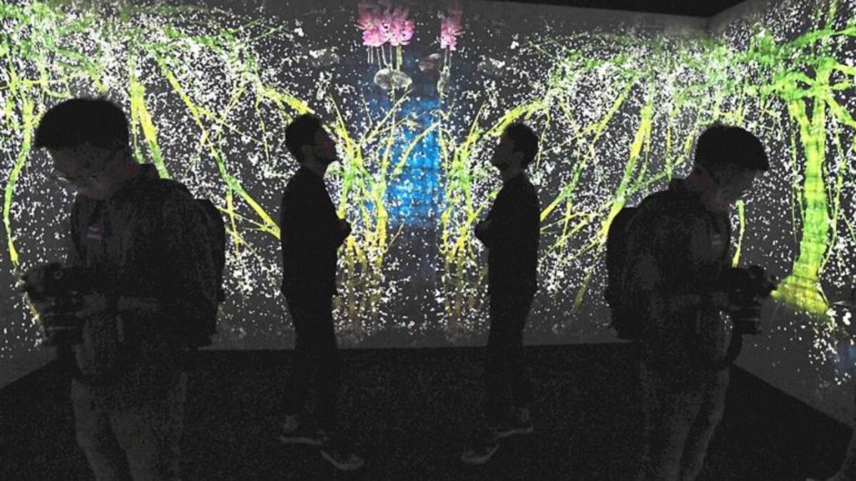 Visitors are silhouetted against a large-scale interactive digital installation by Japan-based teamLab titled 'Walk, Walk, Walk: Search Deviate, Reunite' at the Light To Night festival in Singapore last month. (AFP)