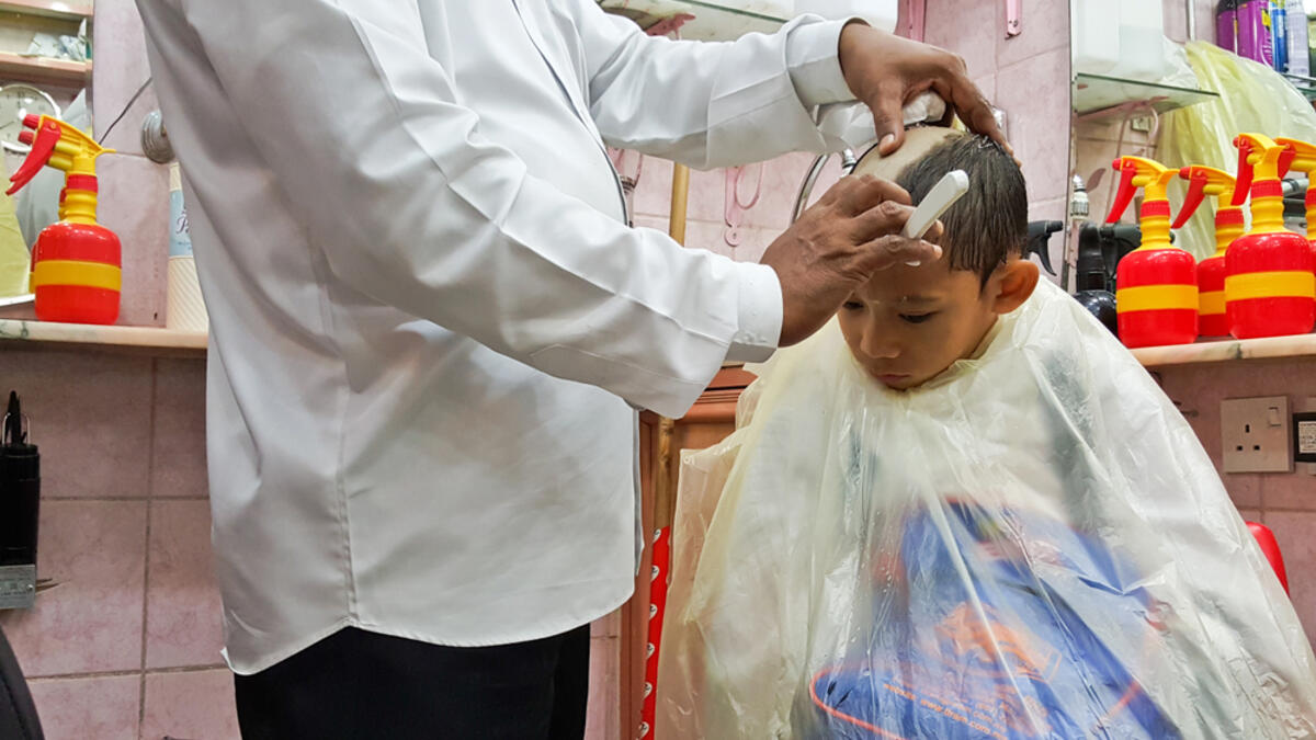 A young muslim boy getting his hair shaved as a rule to complete his rites of umrah and he can be free of his ihram and ihram's limitation (Shutterstock/File Photo)