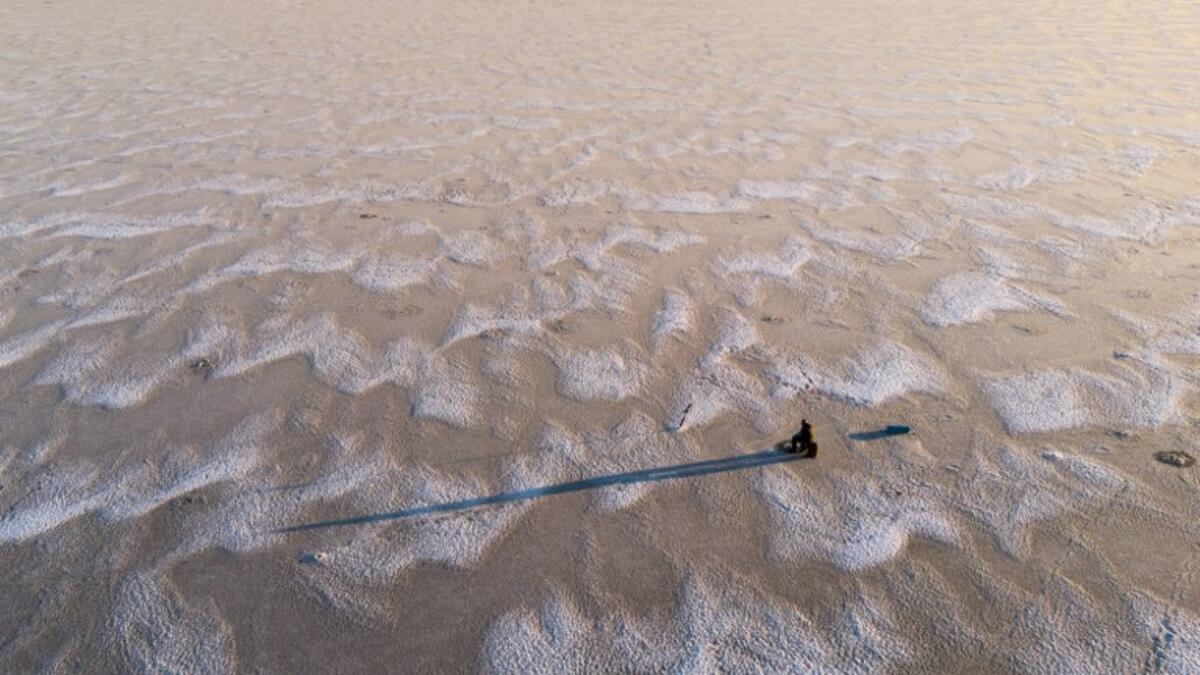 An aerial view shows a man sitting waiting near a hole drilled into the frozen sea as he ice fishes on the Gulf of Bothnia, near Vaasa, Western Finland on December 28, 2018, where winter daylight last for some four hours. 
Olivier MORIN / AFP
