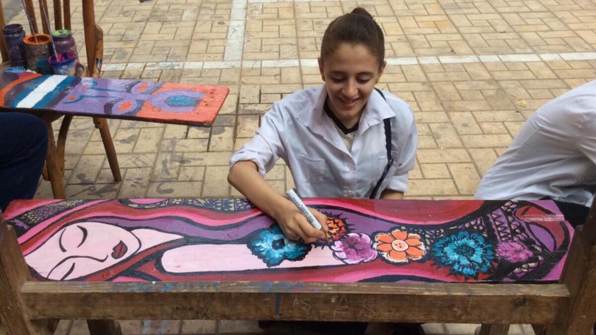 Girls painting school chairs in Giza. (Maha Zein/ Facebook)