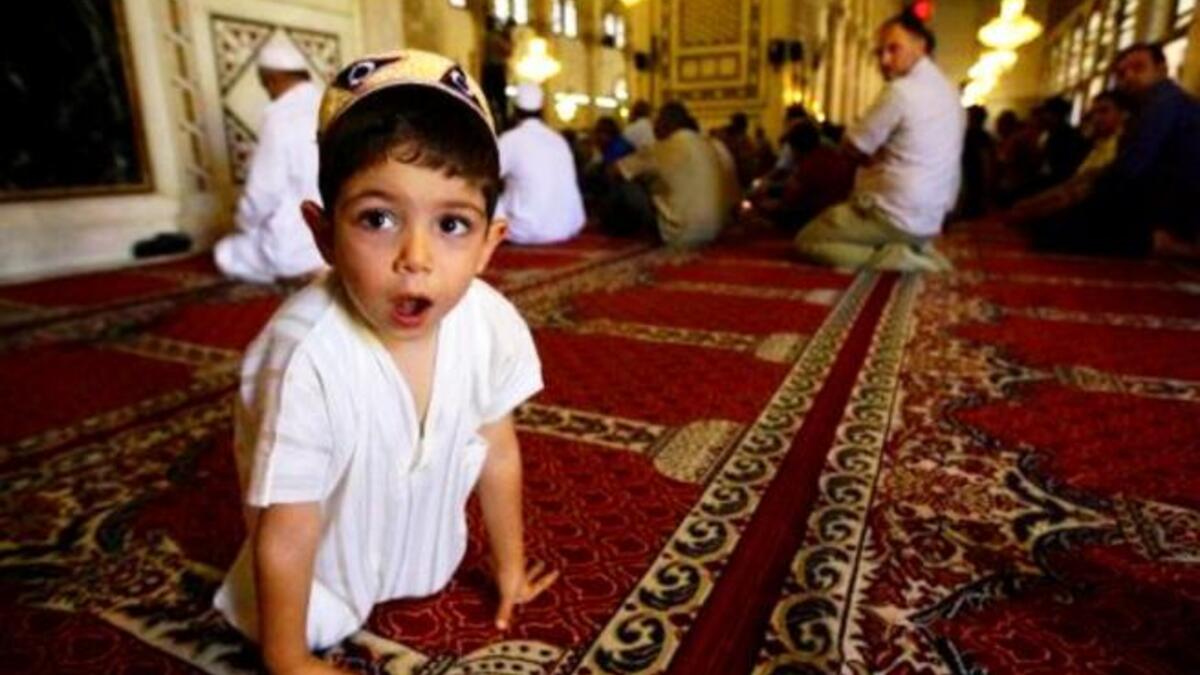Syria, Damascus: Hoping for a peaceful religious festival away from the wider Syrian turmoil this Eid, a Syrian Muslim boy attends the weekly Friday prayer at the Omayyad Mosque in central Damascus.