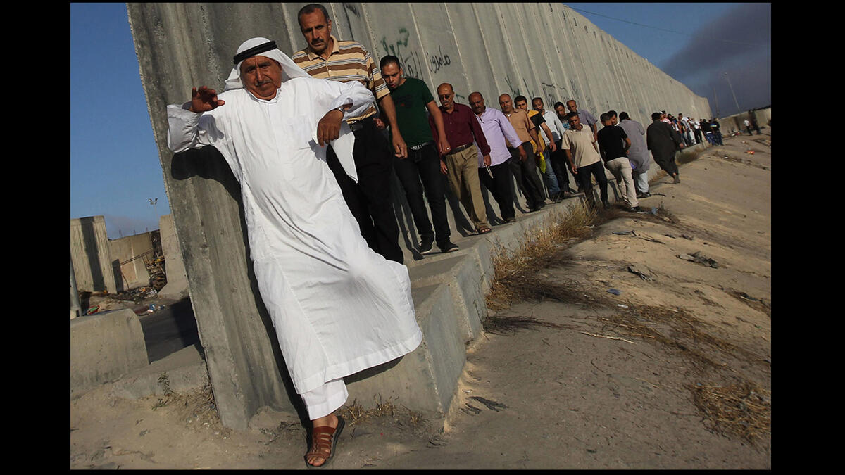 palestinians queue at israeli checkpoint