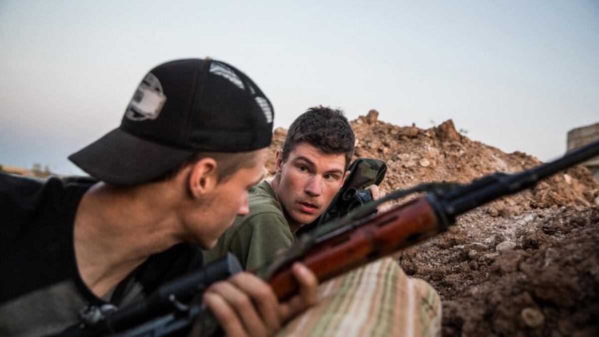 Ex-US marines aged 23 and 24 from the US, nicknamed by Kurdish fighters as ‘Hewal Agir’ (R) and ‘Hewal Agit’, guard a position outside Tal Tamr during clashes with Daesh fighters on April 17, 2015.