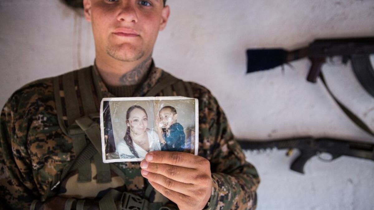‘Hewal Dilsad,’ a 26-year old from the US, shows a picture of his wife and son as he poses for a photo in Tal Tamr on April 14, 2015.