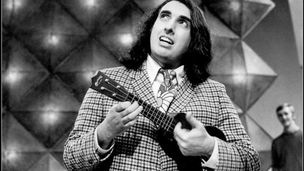 a
Lebanese-American folk singer "Tiny Tim" (born Herbert Khaury in 1932) was a ukulele player most famous for his version of "Tiptoe Through the Tulips" sung in a high falsetto voice. He famously got married on Johnny  Carson’s Tonight Show in 1969. See him on YouTube — he could be Russell Brand’s dad!