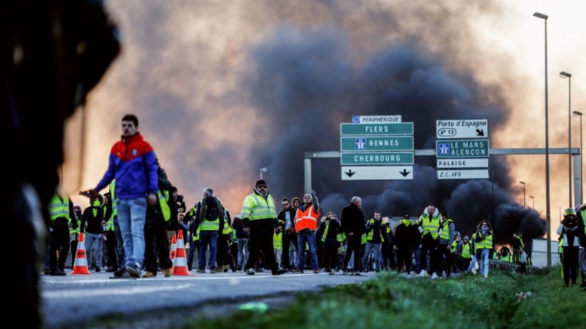 People stand in front of gendarmes on Caen's circular road on November 18, 2018 in Caen.
CHARLY TRIBALLEAU / AFP