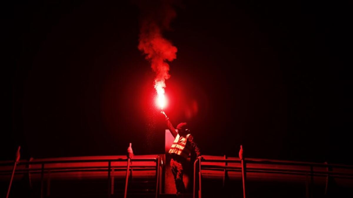 A protester holds a burning flare during a blocking of the ring road of Caen, northwestern France, on November 18, 2018 in Caen.
CHARLY TRIBALLEAU / AFP