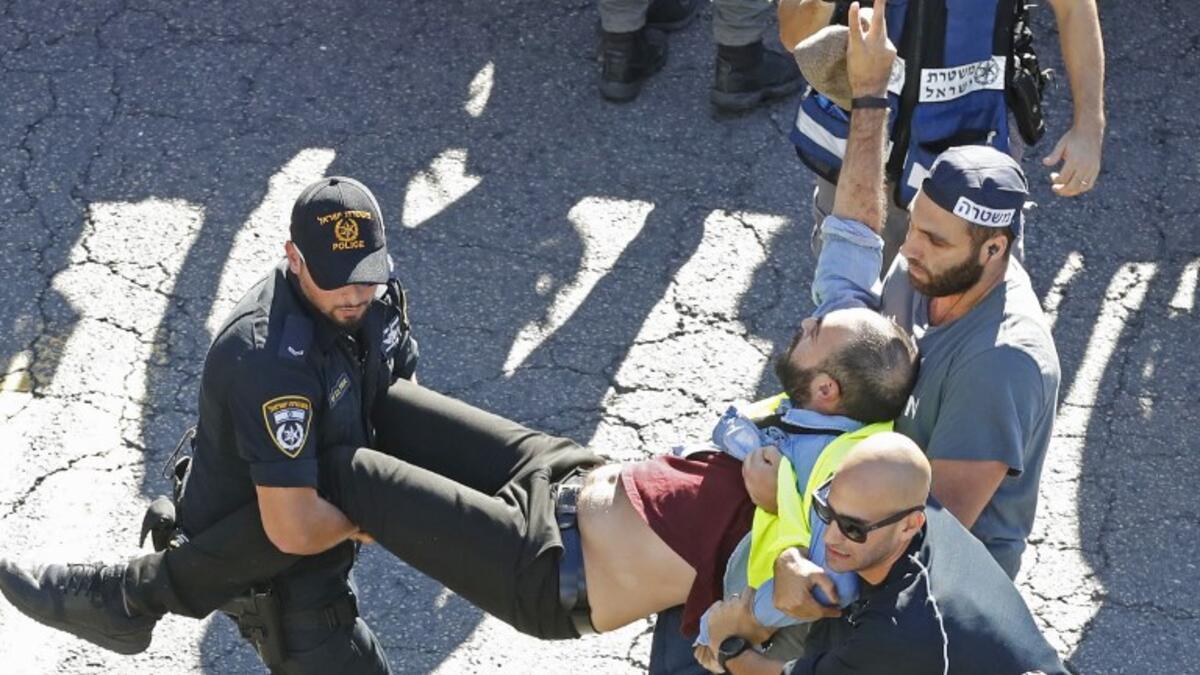 Members of the Israeli security forces arrest a protester wearing a yellow vest, during demonstrations against the rising cost of living on December 14, 2018.
JACK GUEZ / AFP