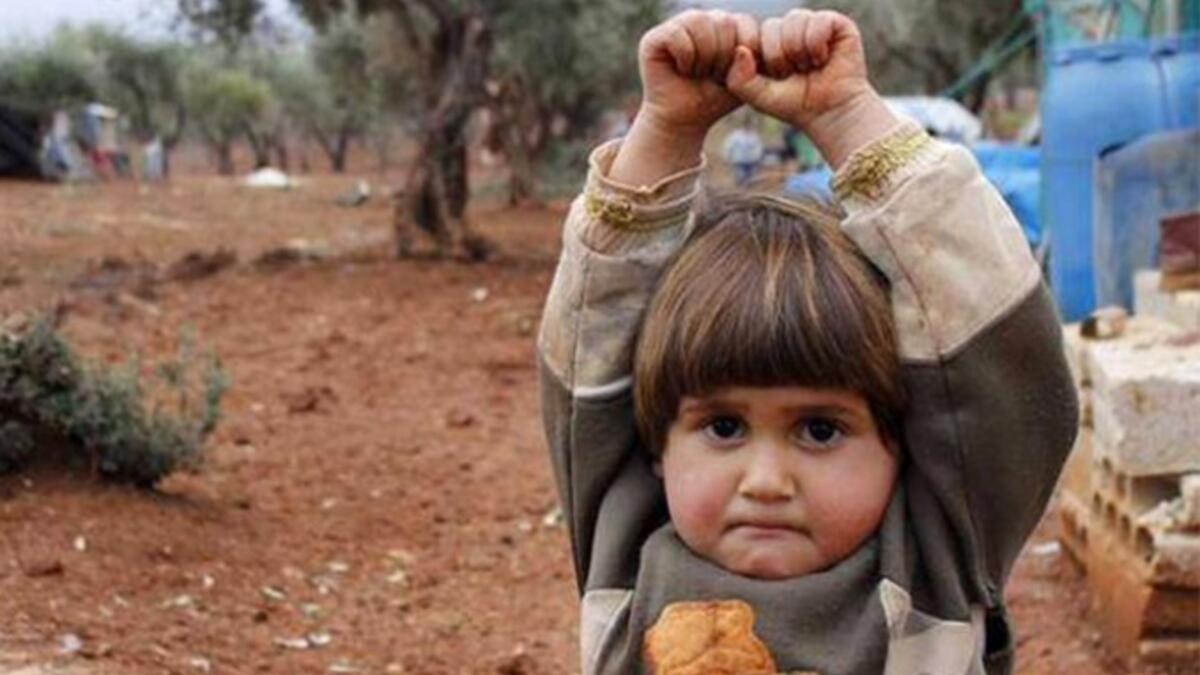 Hudea Syrian girl hands raise at camera