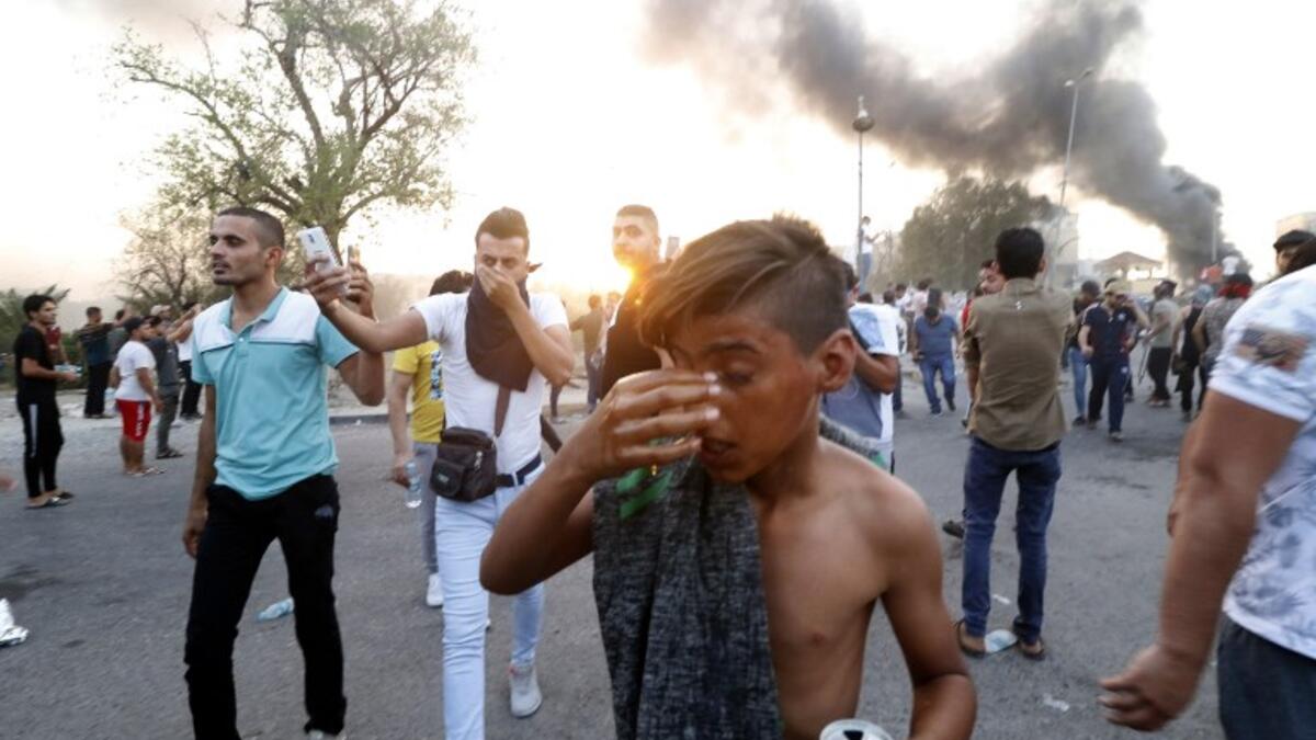 An Iraqi protester reacts to tear gas fired by security forces during a protest against the government and the lack of basic services, on August 31, 2018 in the southern city of Basra. 
Haidar MOHAMMED ALI / AFP