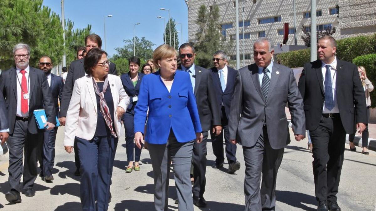 German Chancellor Angela Merkel walks during her Jordan visit in the German-Jordanian University in the Jordan city of Madaba, June 21, 2018. (AFP Ahmad Abdo)