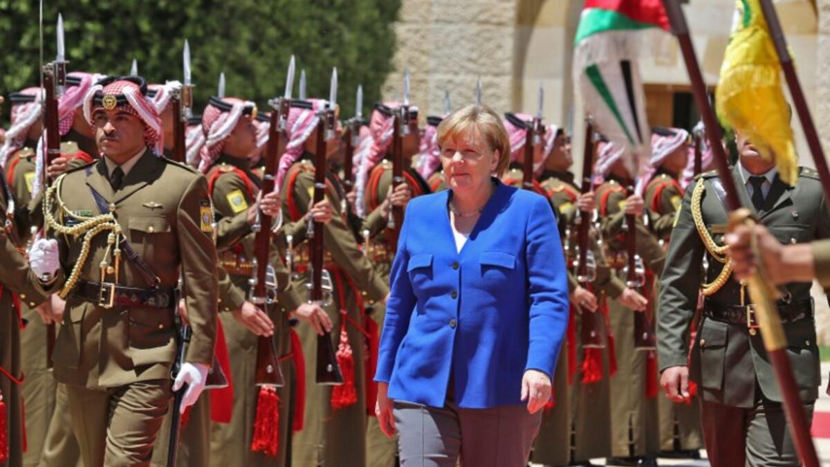 German Chancellor Angela Merkel reviews an honour guard upon her arrival at the Jordan Royal Palace in Amman June 21, 2018. (AFP/Khalil Mazraawi)