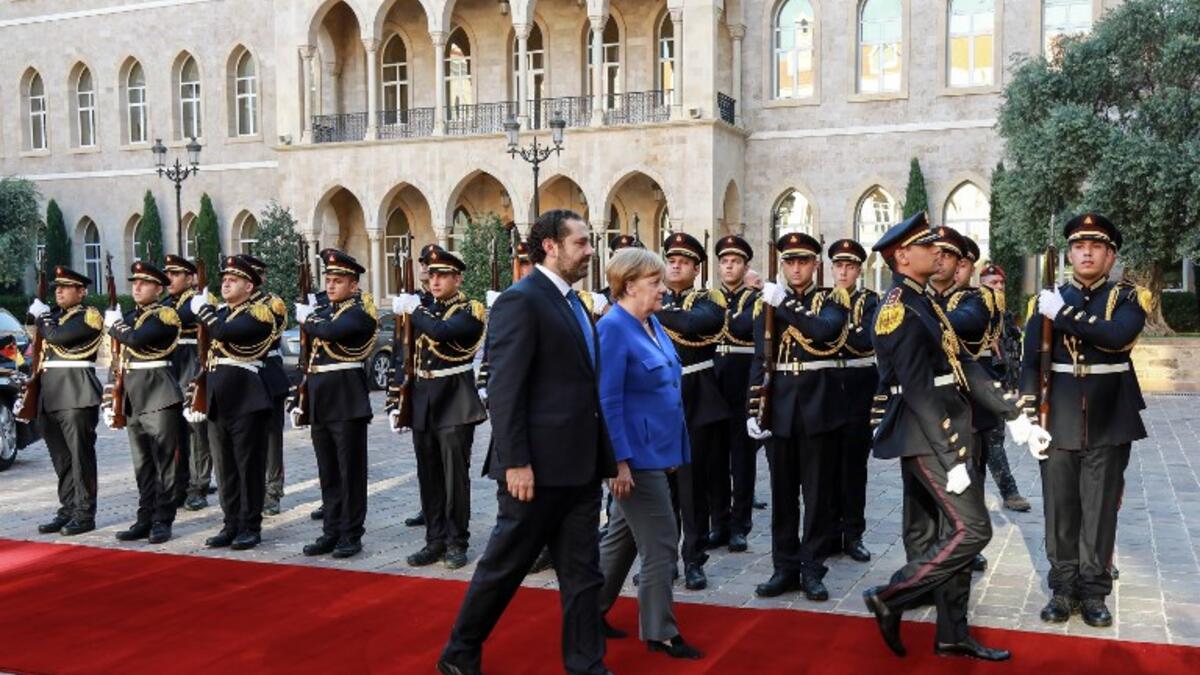 Lebanese Prime Minister Saad Hariri (L) receives German Chancellor Angela Merkel (C) inspect an honour guard as she arrives at the prime minister's office in the Lebanese capital Beirut, June 21, 2018. (AFP/Anwar Amro)