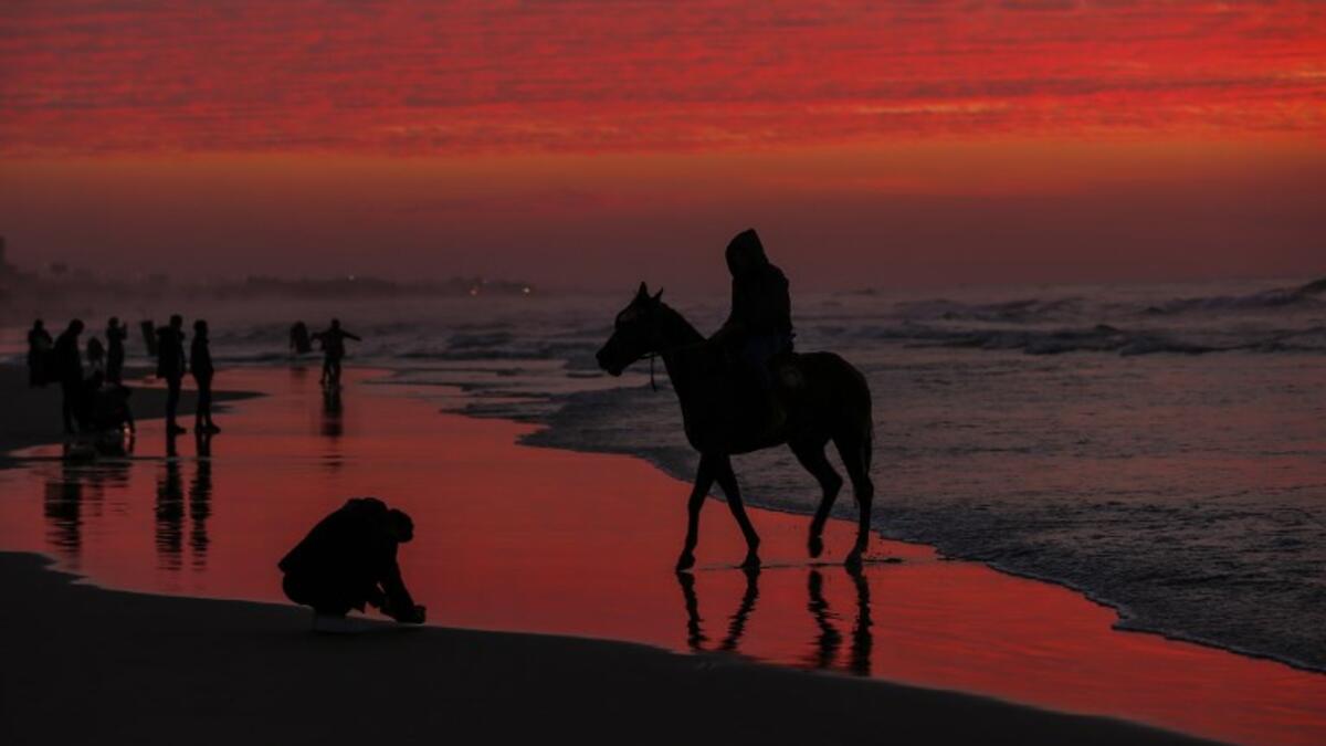 A Palestinian horseman rides on the beach at sunset west of in Gaza city on December 31, 2018. 
MAHMUD HAMS / AFP