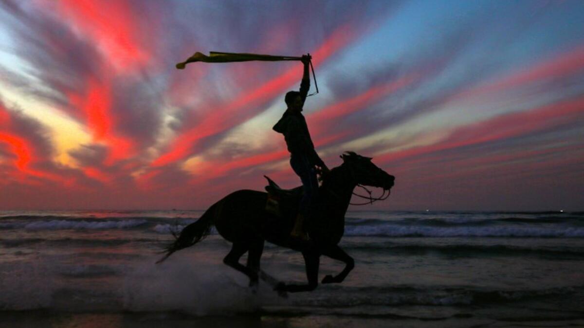 A Palestinian horseman rides on the beach at sunset west of in Gaza city on December 31, 2018. 
MAHMUD HAMS / AFP