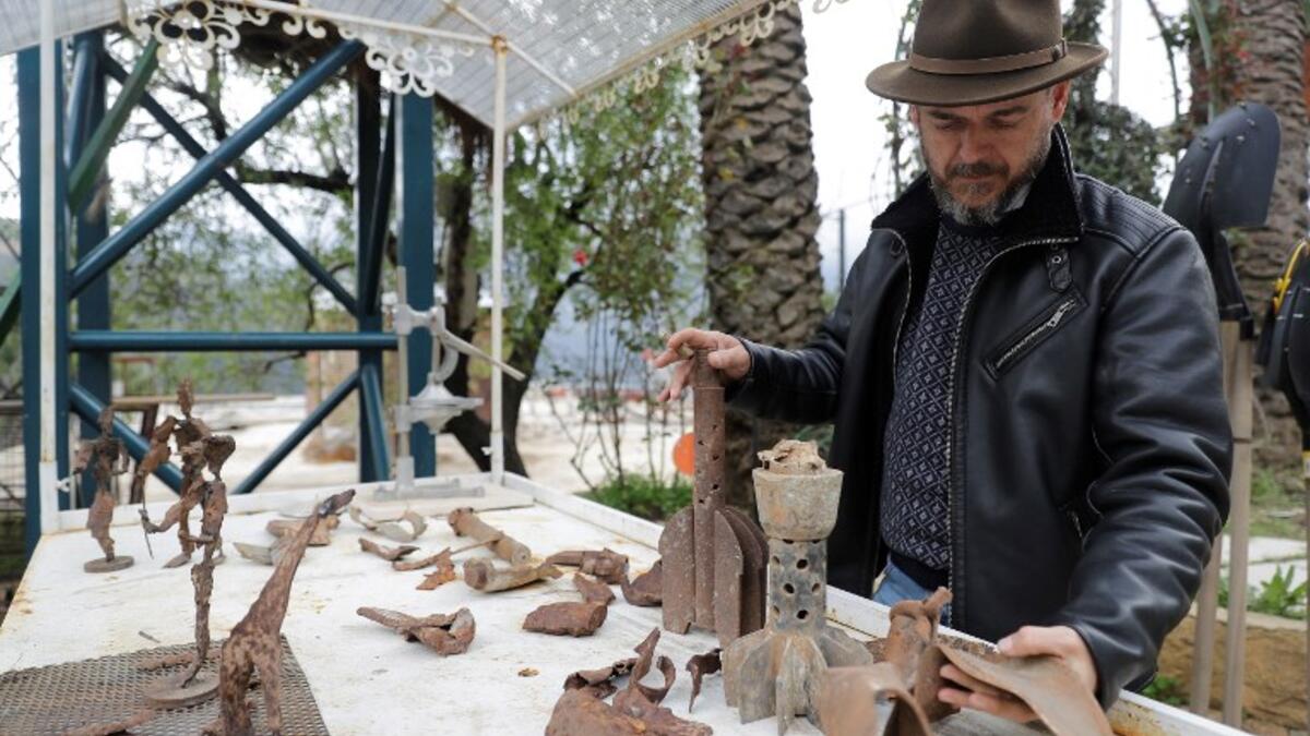 Lebanese Artist Charles Nassar inpsects his sculptures made out of artillery shrapnels in the village of Remhala, south of Beirut, on March 7, 2019.
JOSEPH EID / AFP